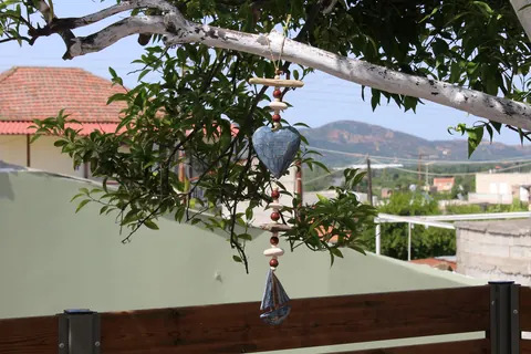 A wooden heart hanging from a branch over the fence