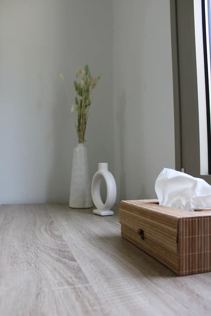 Dried grasses in a white vase and a rattan box in the corner of the Mint Room